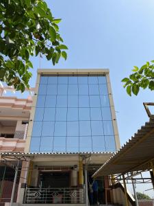 un edificio alto con una fachada de cristal en OYO Hotel Red Cross(banquet&restra) en Kānpur
