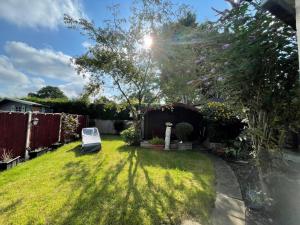 a yard with a chair in the grass at Addlestone Tranquil Spacious Three Bedroom Bungalow in Addlestone