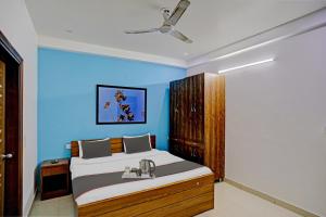 een slaapkamer met een bed en een blauwe muur bij Collection O Hotel Daffodils in Gurgaon