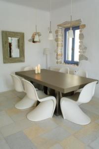 een eetkamer met een tafel en witte stoelen bij Kalma villa in Santa Maria