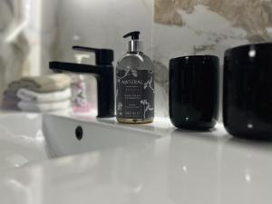 Una botella de jabón encima de un lavabo. en Guest House Eden en Bihać