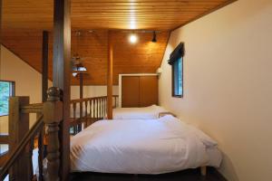 a bedroom with a bed and a wooden ceiling at CLIMB NASU in Nasu