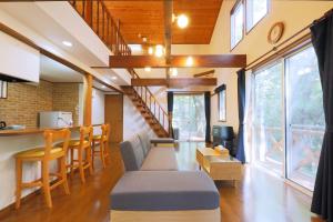 a living room with a couch and a staircase at CLIMB NASU in Nasu