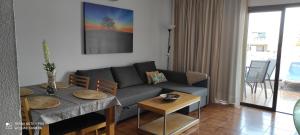 - un salon avec un canapé et une table dans l'établissement Apartment with pool and gardens near the coast, à San Miguel de Abona