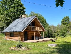 a log cabin with a deck and a picnic table at Salmiņu Pirtsmāja - Sauna House in Pastva Barbern