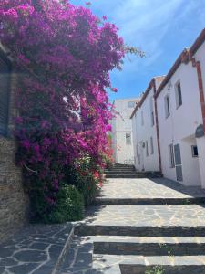 een pad met paarse bloemen op een gebouw bij Canvas Apartments&Lofts in Cadaqués