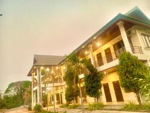 a house with a palm tree in front of it at Garden Resort in Vang Vieng