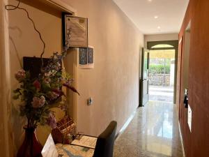 un pasillo con un jarrón de flores en la pared en Albergo Tecla en Lazise