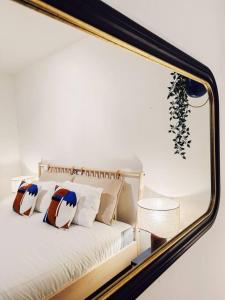 ein Spiegel, der ein Bett mit Kissen reflektiert in der Unterkunft Colorful Coziness City Apartment in Gent