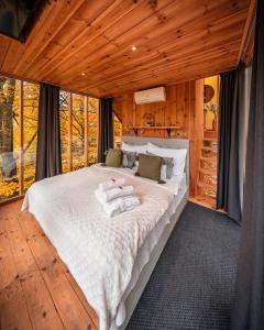 1 dormitorio con 1 cama grande en una cabaña en TreeHouses Noszvaj, en Noszvaj