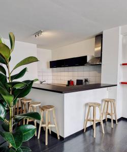 eine Küche mit einer Reihe von Hockern und einer Theke in der Unterkunft Colorful Coziness City Apartment in Gent