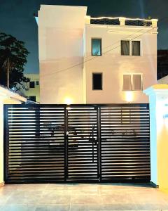 a black gate in front of a white house at JQ.APARTMENTS in Accra