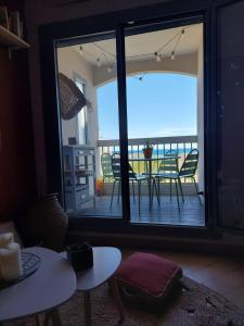 a room with a view of a balcony with tables and chairs at La pénate de Saint Cyp - résidence les Frégates vue mer, Piscine in Saint-Cyprien