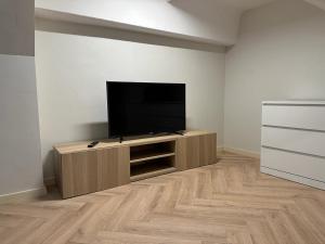 a living room with a flat screen tv on a entertainment center at Sniego Apartments in Vilnius