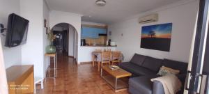 - un salon avec un canapé et une table dans l'établissement Apartment with pool and gardens near the coast, à San Miguel de Abona
