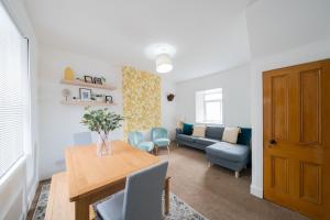 a living room with a table and a couch at Coorie by the Coast - Arbroath in Arbroath