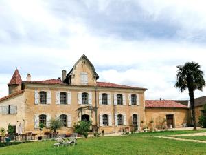 an old house with a palm tree in front of it at Château d'Esplavis in Eauze