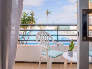una silla blanca en el balcón con vistas al océano en Live Punta Columbus Pool & Beach Front, en Punta del Hidalgo