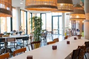 a restaurant with tables and chairs and large windows at greet Hotel Rennes Pace in Pacé