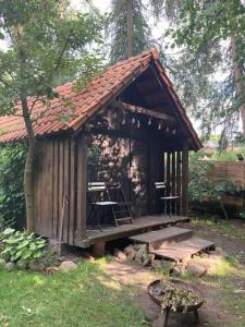 a small wooden cabin with a table and a bench at Domek na górce in Rańsk