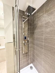 um chuveiro com uma porta de vidro na casa de banho em Luxury 3 Bedroom Apt. Leeds Centre em Leeds