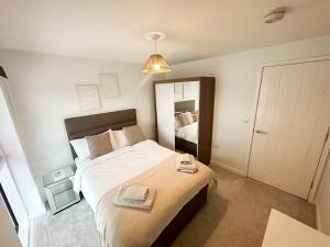 um quarto com uma cama grande e um espelho em Luxury 3 Bedroom Apt. Leeds Centre em Leeds