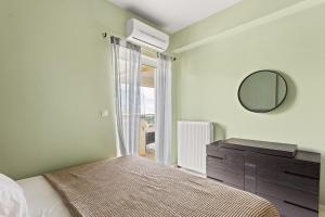 a bedroom with a bed and a mirror and a dresser at Emerald Elegance in Kalamata