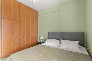 a bedroom with a large bed with wooden cabinets at Emerald Elegance in Kalamata