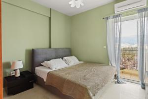 a bedroom with a bed and a large window at Emerald Elegance in Kalamata
