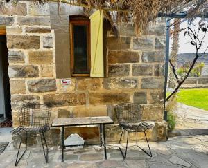 two chairs and a table in front of a stone building at Droombos in Windhoek