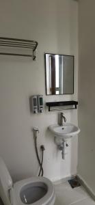 uma casa de banho com um WC, um lavatório e um espelho. em Tang Hotel em Alor Setar