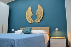 1 dormitorio azul con 1 cama con alas en la pared en Anna's B&B en Pozzuoli