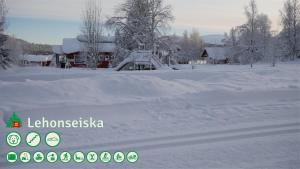 een sneeuwbedekte tuin met een huis op de achtergrond bij Talo Ylläs in Äkäslompolo