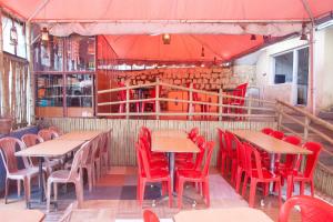 un restaurante vacío con mesas y sillas rojas en Flagship Key 2 Heaven en Ooty