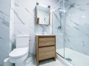 a bathroom with a toilet and a sink and a shower at Heathrow Airport Apartments by Elegance Living in Hounslow