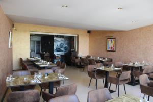 a dining room with tables and chairs and a screen at Le Commerce in Dompaire