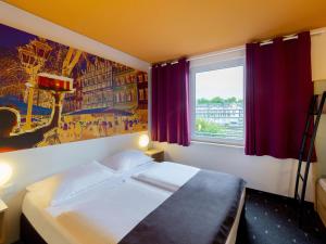 デュッセルドルフにあるB＆B ホテル デュッセルドルフ シティのベッドと窓が備わるホテルルーム