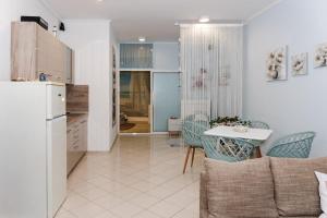 a kitchen and a living room with a table and a refrigerator at Луксозен апартамент Далия in Varna City +6 photos