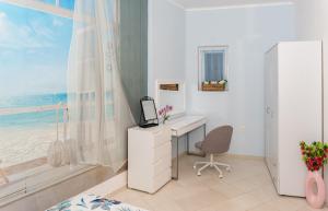 a bedroom with a desk and a window with the ocean at Луксозен апартамент Далия in Varna City
