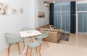 a living room with a table and chairs and a couch at Луксозен апартамент Далия in Varna City