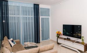 a living room with a couch and a flat screen tv at Луксозен апартамент Далия in Varna City