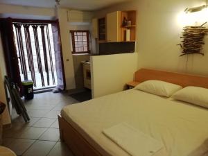 a bedroom with a large bed and a kitchen at Studio Old Centar in Cres