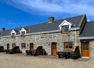 a building with tables and chairs in front of it at Hook Holiday Cottage in Kilmore Quay