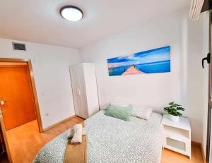 a white room with a bed and a table at El Elefante del Pilar ComoTuCasa in Zaragoza