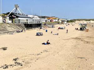 eine Gruppe von Menschen an einem Sandstrand in der Unterkunft Lush Porthcawl Large Spacious 2 bedroom Apt, Parking, Garden access, Prime Location in Porthcawl