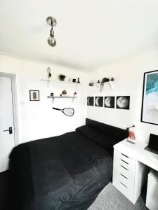 都柏林的住宿－Custom House, 1 room, Dublin 1，一间卧室配有一张黑色的床和一张书桌