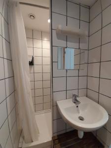 een witte badkamer met een wastafel en een douche bij Au Spatial in Amiens