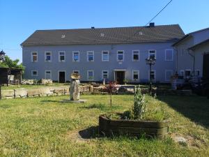 un gran edificio blanco con un patio delante en Gutshof und Ferienwohnung Proft 