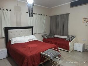 1 dormitorio con 2 camas con sábanas rojas en Casa Las Moras en La Rioja