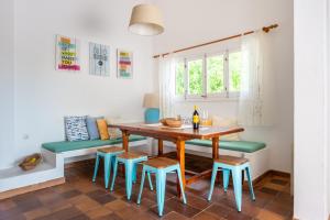 uma sala de jantar com uma mesa de madeira e cadeiras azuis em Can Pep Toni em Cidade de Ibiza